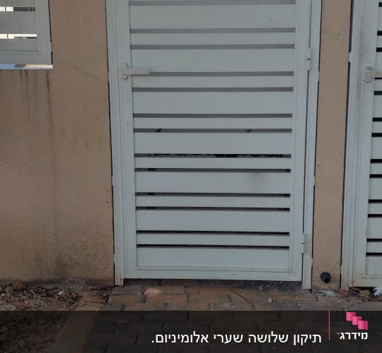 שער אלומיניום ליד שביל מרוצף בלבנים